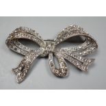 A white metal and paste set ribbon bow brooch, 77mm.