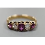 An 18ct gold, three stone ruby and two stone diamond set half hoop ring, size O, gross weight 3.7