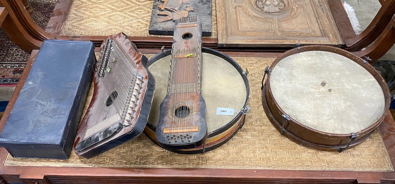 A group of assorted musical instruments comprising two large tambourines, two zithers and a Zenith