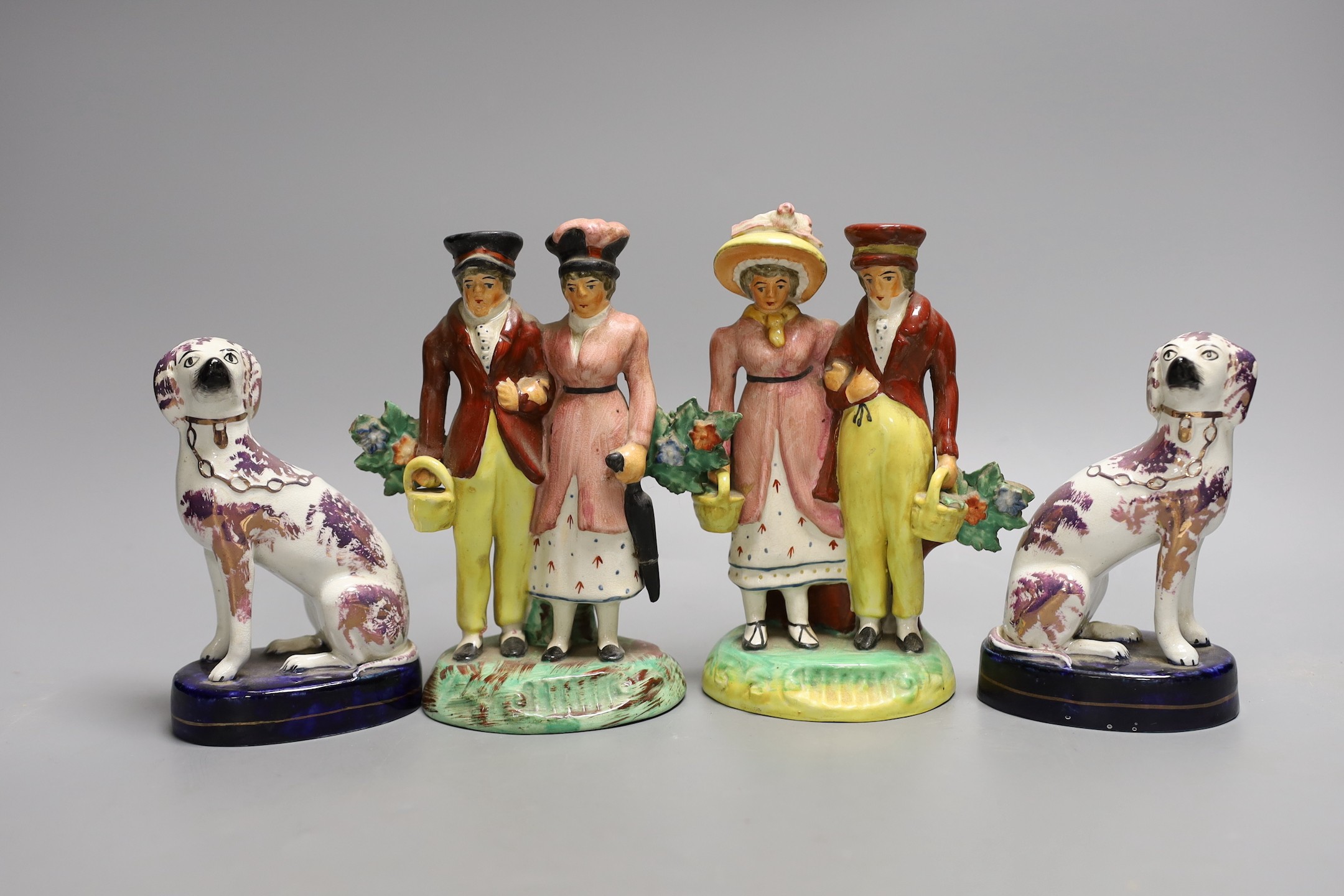 A pair of Staffordshire pink lustre spaniels and a pair of similar groups of a dandy and