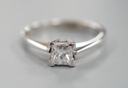 A modern 750 white metal and solitaire princes cut diamond set ring, size L/M, gross weight 2.6