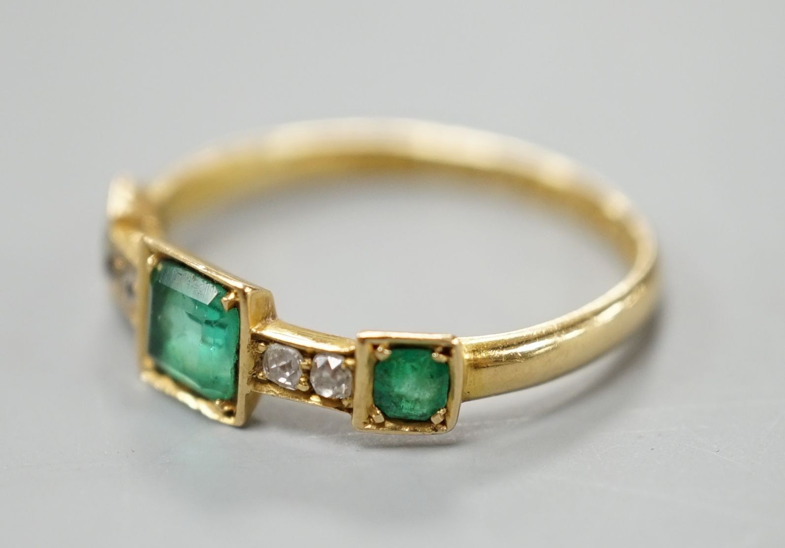 A George V 18ct gold, three stone emerald and four stone diamond chip set half hoop ring, size L, - Image 2 of 4
