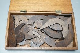 A quantity of cut wood shapes, letters and quotation marks, possibly a puzzle, in wooden box