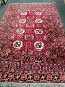An Afghan red ground carpet, 290 x 198cm