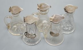 Five early 20th century and later silver mounted glass whisky tot jugs by Hukin & Heath, including a