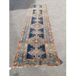 A North West Persian blue ground runner, (heavily worn) 404 x 101cm