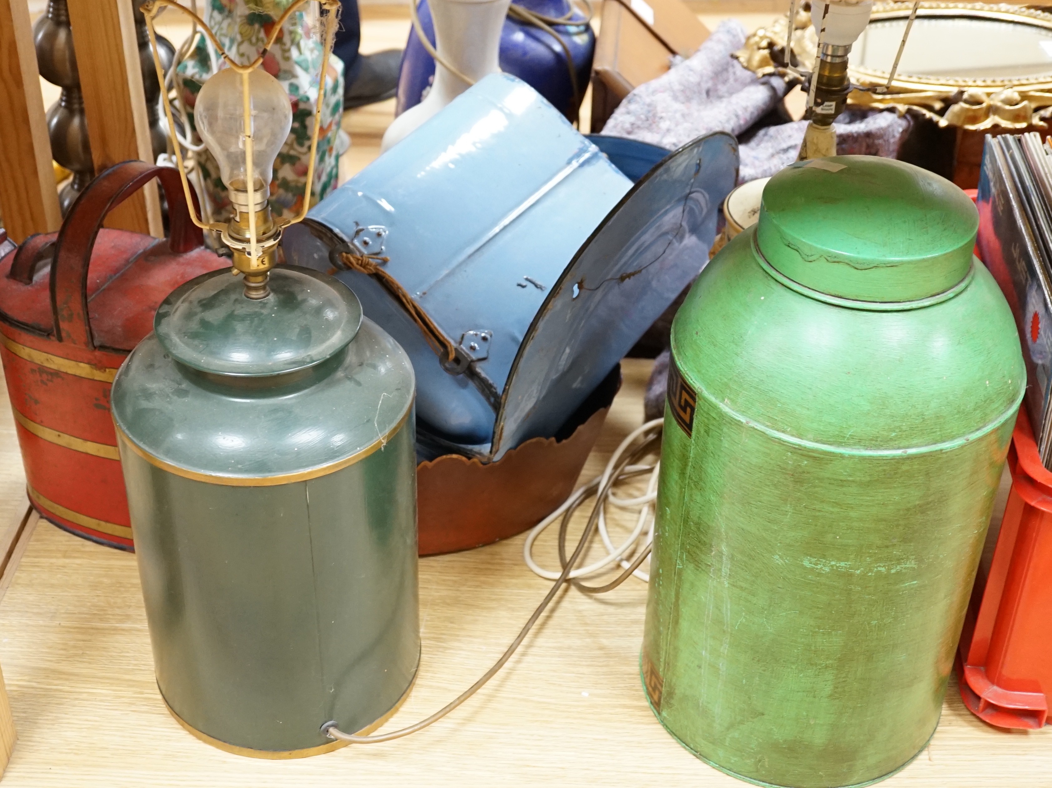 A collection of various toleware items, including two tea canisters, one mounted as a lamp, a