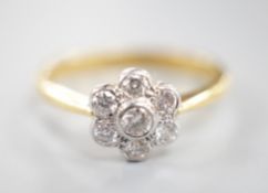 A modern 18ct gold and collet set seven stone diamond set flower head cluster ring, size O, gross
