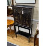 A chinoiserie lacquered two door side cabinet on later stand, width 64cm, depth 27cm, height 130cm