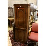 A small early 19th century pine two door standing corner cabinet, (lacking back leg) width 58cm,