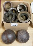 A collection brass brewery bung collars and two cannon balls