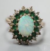 An 18ct white metal, white opal, emerald and diamond set oval cluster ring, size O, gross weight 6.2