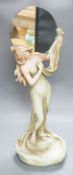 A continental Art Nouveau ceramic figure of a lady holding a mirror, 57cms high not including