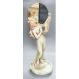 A continental Art Nouveau ceramic figure of a lady holding a mirror, 57cms high not including