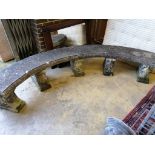 A reconstituted stone curved garden bench on five scroll supports, length 280cm, height 44cm