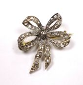 An early 20th century Austro-Hungarian yellow metal and diamond cluster set ribbon bow brooch, 26mm,