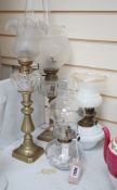 Four assorted glass and brass oil lamps, tallest 56cms high,