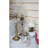 Four assorted glass and brass oil lamps, tallest 56cms high,