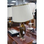 A pair of metal two handled table lamps on marble bases with cream shades, 75cms high,