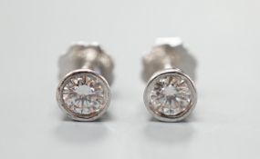 A pair of 750 white metal and collet set solitaire diamond ear studs, gross weight 1.5 grams,
