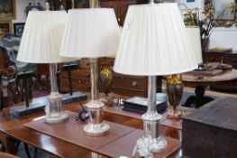 A pair of steel column table lamps, with matching cream silk shades and another similar lamp and