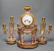 A French ormulu and rouge marble clock garniture, c.1900, with decorative enamel dial, 40cms high.