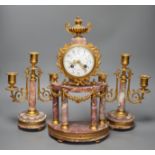 A French ormulu and rouge marble clock garniture, c.1900, with decorative enamel dial, 40cms high.