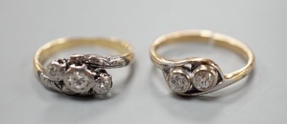 A yellow metal and two stone diamond set crossover ring (shank cut) and a similar illusion set three
