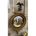 A Regency carved giltwood convex wall mirror with eagle pediment, width 55cm, height 98cm