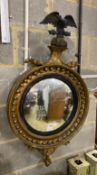 A Regency carved giltwood convex wall mirror with eagle pediment, width 55cm, height 98cm