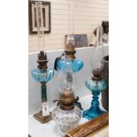 Three blue glass oil lamps and a clear glass oil lamp, tallest 62cms high,