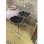 A pair of Harry Bertoia style chrome wired bar chairs with black leather seat pads, width 75cm,