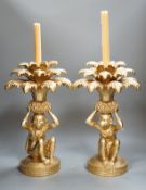 A pair of gilt resin ‘monkey and pineapple’ candlesticks. 37cm tall