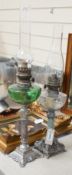 Two metal oil lamps and glass funnels, tallest 66cms high,