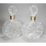 A pair of silver collared cut glass decanters. 27cm high.