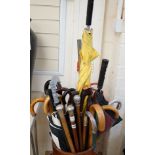 Four assorted white metal mounted walking sticks, sundry walking sticks, umbrellas and canes,