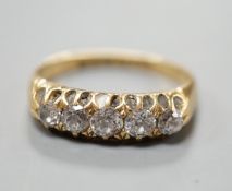 An early 20th century 18ct gold and graduated five stone diamond set half hoop ring, size N/O, gross