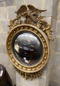 A Regency carved giltwood convex wall mirror with eagle pediment, width 59cm, height 92cm
