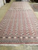 A pair of Bokhara peach ground carpets, 310 x 218cm