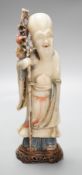 A 18th century Chinese carved soapstone figure of Shao Lou on carved hardwood stand. 24cm high.