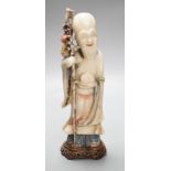 A 18th century Chinese carved soapstone figure of Shao Lou on carved hardwood stand. 24cm high.