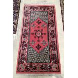 A Turkish red ground multi medallion rug, 137 x 72cm