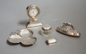 An Edwardian miniature silver-cased mantle timepiece, snuff box, blotter, clover-shaped dish and