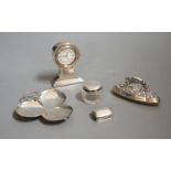 An Edwardian miniature silver-cased mantle timepiece, snuff box, blotter, clover-shaped dish and