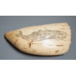 A 19th century scrimshaw carved whales tooth inscribed ‘tooth of sperm whale Phoenix out of Whitby’.
