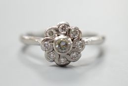 A modern platinum and nine stone diamond set flower head cluster ring, size O, gross weight 5.4