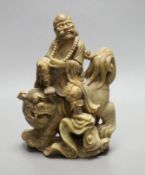A Chinese soapstone group of a luohan riding a lion, 20cm