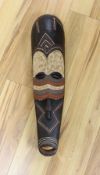 An African carved and painted wood mask. 64cm long