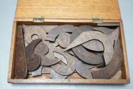 A quantity of cut wood shapes, letters and quotation marks, possibly a puzzle, in wooden box