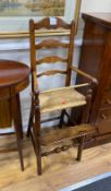 An early 19th century ash and elm ladder back rush seat child's high chair, height 104cm